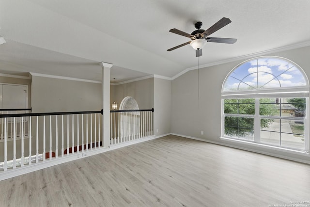 empty room featuring crown molding, wood finished floors, a ceiling fan, and baseboards