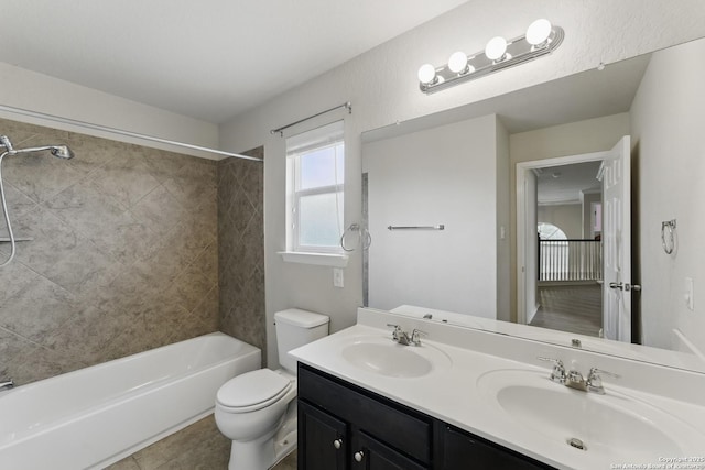 bathroom with toilet, a sink, shower / tub combination, and double vanity