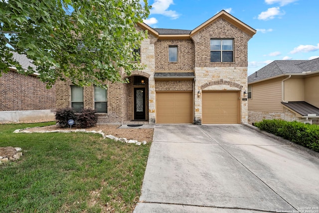 traditional-style home with stone siding, concrete driveway, brick siding, a garage, and a front yard