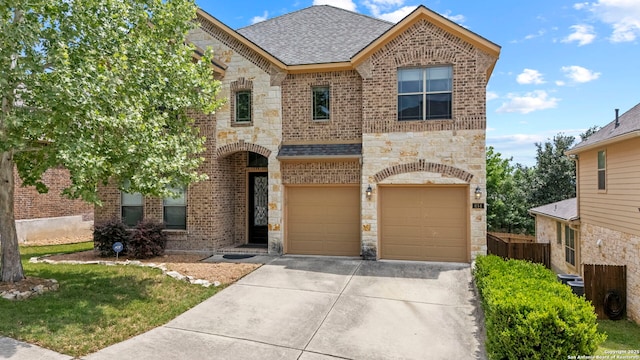 traditional home with a shingled roof, driveway, stone siding, brick siding, and a garage