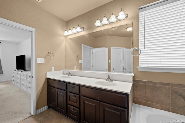 bathroom with tile patterned flooring, a bath, a sink, and double vanity