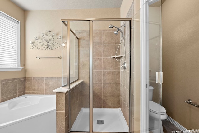 bathroom with a shower stall, a garden tub, and toilet