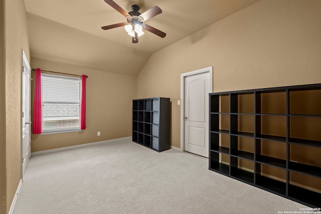 interior space with lofted ceiling, a ceiling fan, baseboards, and carpet floors