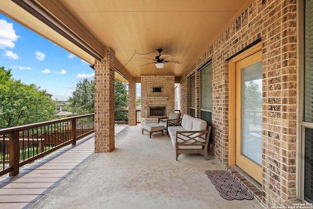 view of patio / terrace featuring an outdoor stone fireplace and ceiling fan
