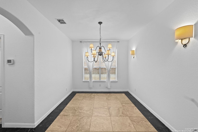 unfurnished dining area featuring baseboards, visible vents, arched walkways, and a chandelier