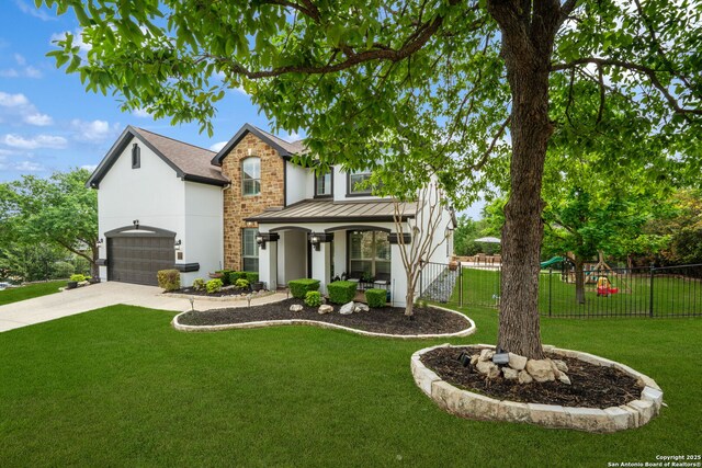 traditional-style home featuring fence, driveway, a front yard, and stucco siding