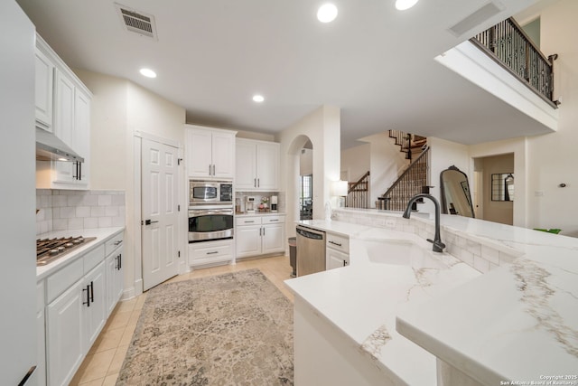kitchen with stainless steel appliances, visible vents, a sink, and tasteful backsplash