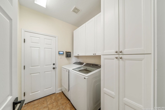 laundry room with cabinet space, independent washer and dryer, and visible vents