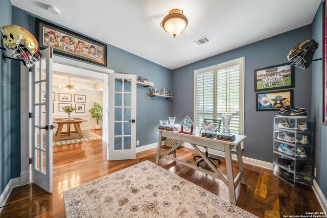 home office featuring wood finished floors, visible vents, baseboards, and french doors
