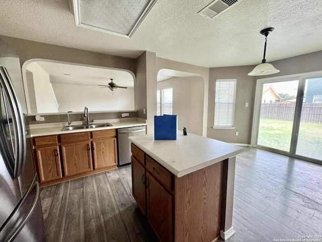 8755 Sunview Park, San Antonio, TX 78224 - kitchen featuring stainless steel appliances, hardwood / wood-style flooring, arched walkways, light countertops, and a textured ceiling