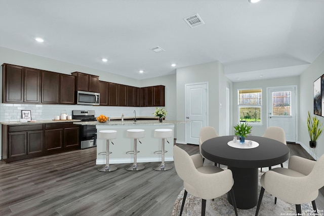 dining area with dark wood finished floors, baseboards, visible vents, and recessed lighting