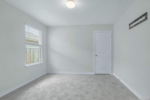 carpeted empty room featuring baseboards