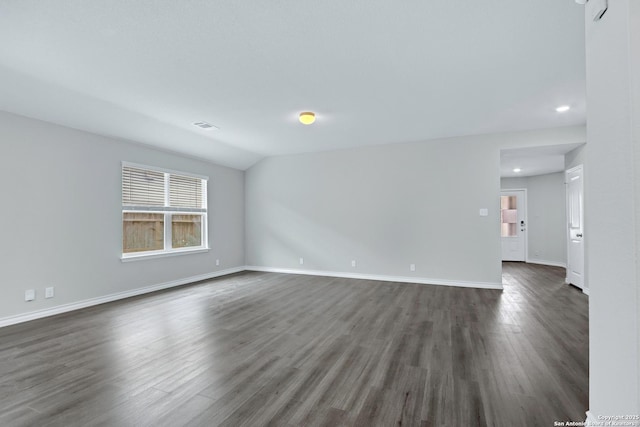 spare room with dark wood finished floors, vaulted ceiling, visible vents, baseboards, and recessed lighting