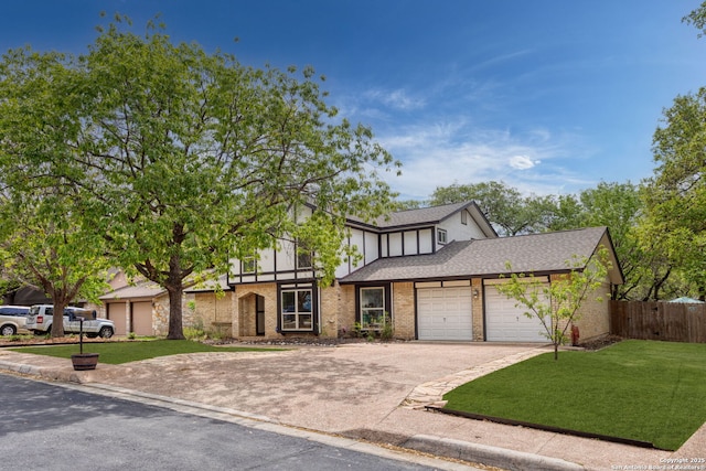 view of front of home with a front lawn, aphalt driveway, a shingled roof, an attached garage, and fence