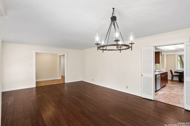 interior space featuring baseboards, wood finished floors, a sink, and a chandelier