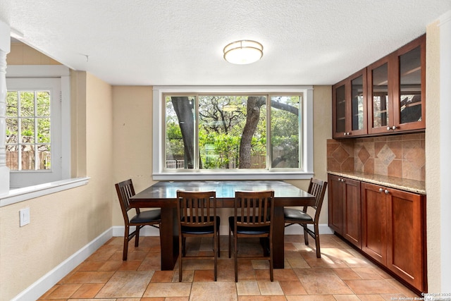 dining space with baseboards and a textured ceiling