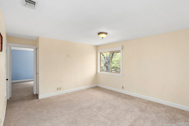carpeted spare room featuring visible vents and baseboards