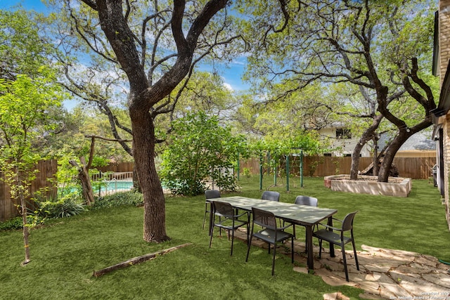 view of yard featuring a fenced backyard and outdoor dining area