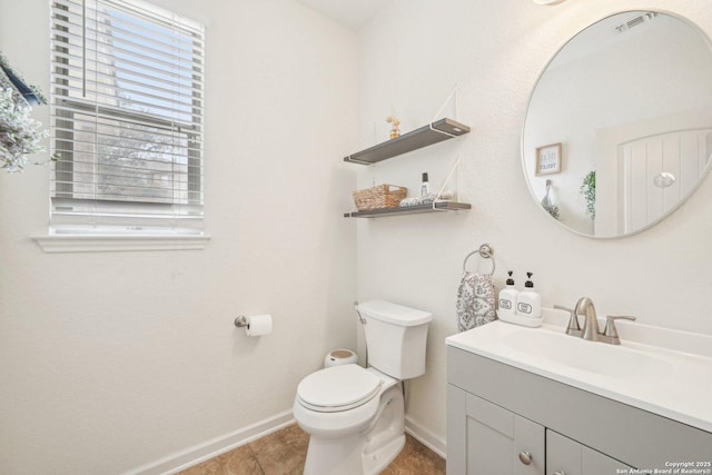 half bathroom featuring tile patterned flooring, visible vents, toilet, vanity, and baseboards