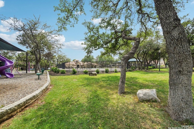 view of home's community with playground community and a lawn