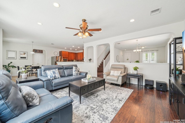 living area with ceiling fan with notable chandelier, visible vents, arched walkways, and recessed lighting