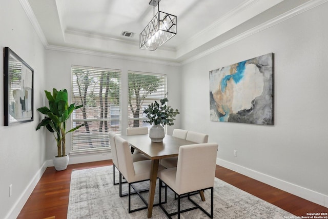 dining area featuring visible vents, wood finished floors, and a tray ceiling