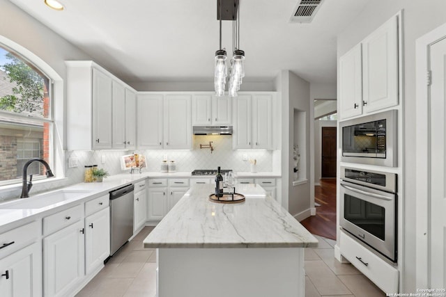 kitchen featuring a sink, appliances with stainless steel finishes, white cabinets, under cabinet range hood, and visible vents
