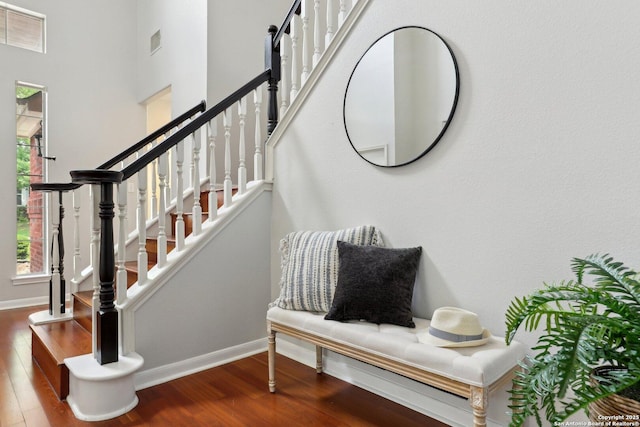 stairway featuring baseboards, wood finished floors, and visible vents