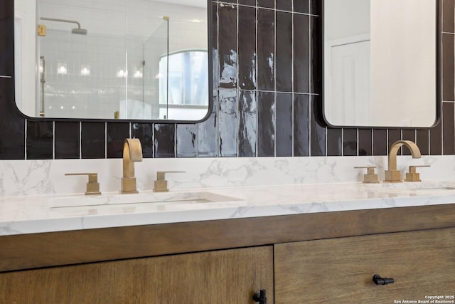 bathroom with double vanity, a shower, and a sink