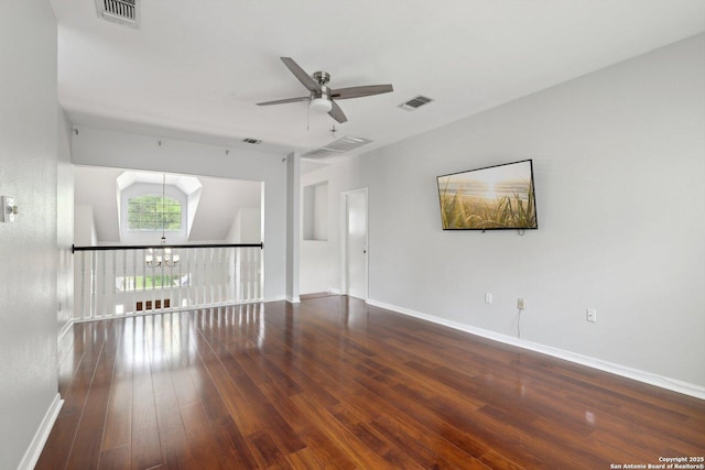 spare room with ceiling fan with notable chandelier, baseboards, visible vents, and wood-type flooring