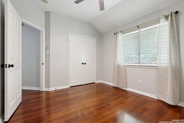 unfurnished bedroom featuring vaulted ceiling, wood finished floors, a closet, baseboards, and ceiling fan