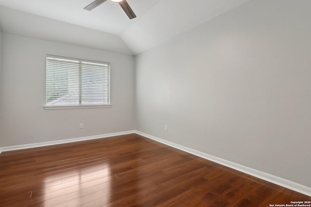 spare room featuring vaulted ceiling, ceiling fan, baseboards, and dark wood-type flooring
