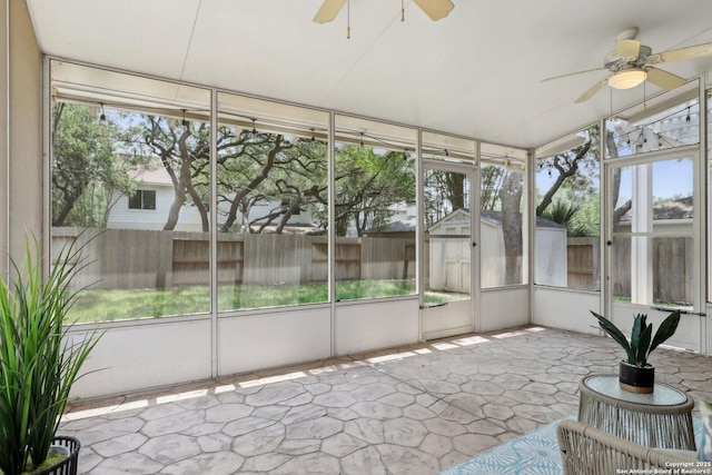 unfurnished sunroom featuring a wealth of natural light and a ceiling fan