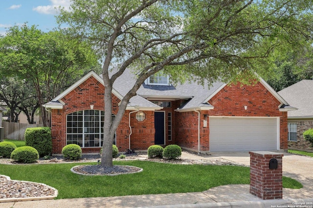 traditional-style house with concrete driveway, brick siding, roof with shingles, and a front yard