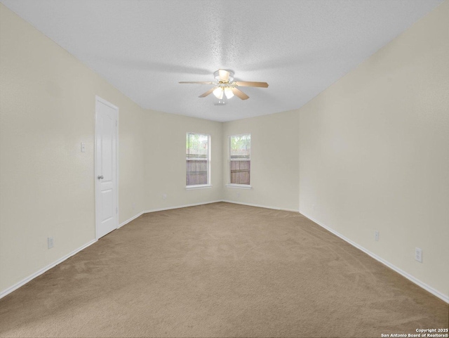 carpeted empty room featuring baseboards, a ceiling fan, and a textured ceiling