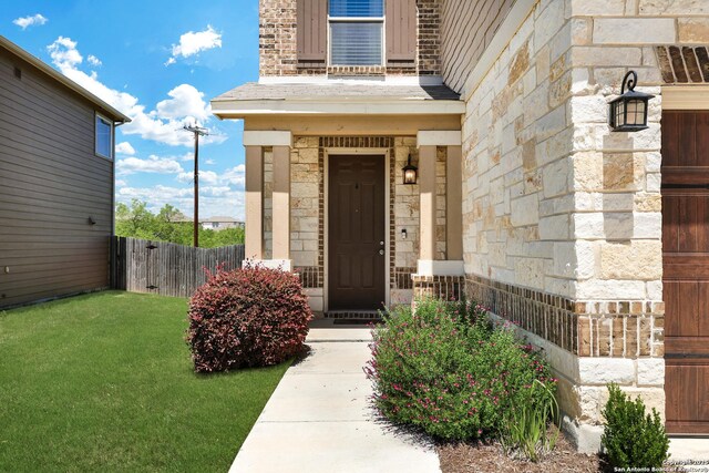 7143 Dulce Mdw, San Antonio, TX 78252 - entrance to property featuring a lawn, fence, and stone siding