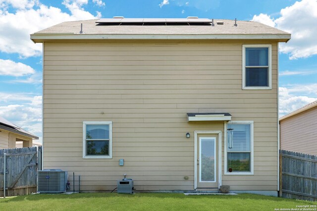 7143 Dulce Mdw, San Antonio, TX 78252 - rear view of house featuring fence, a yard, cooling unit, and solar panels