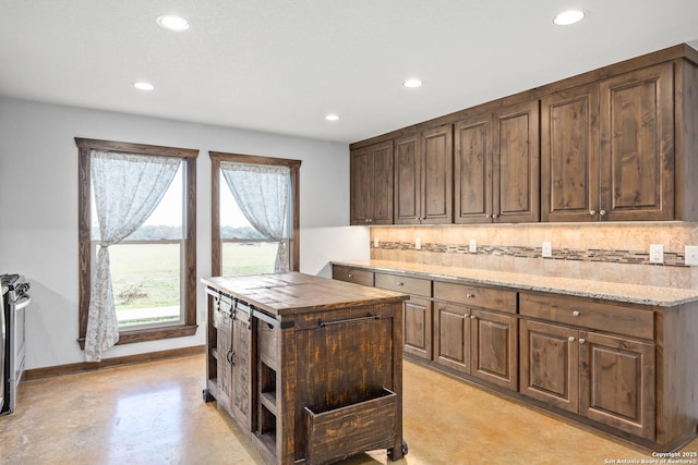 kitchen featuring butcher block counters, concrete flooring, recessed lighting, and backsplash