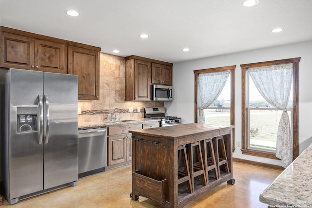 kitchen with stainless steel appliances, a sink, recessed lighting, backsplash, and butcher block countertops