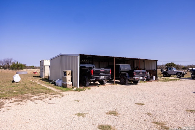 view of pole building with a carport and gravel driveway