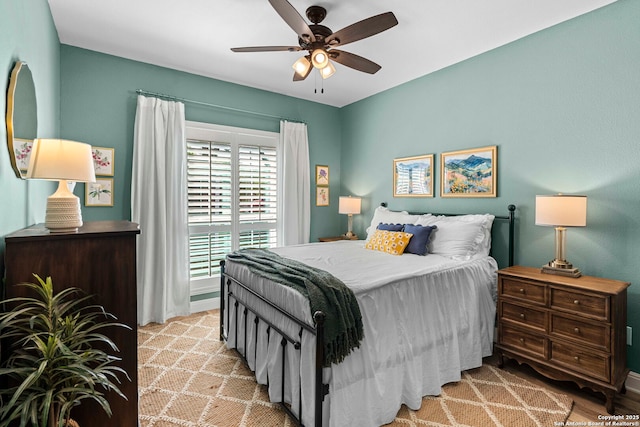 bedroom featuring baseboards, a ceiling fan, and light wood-style flooring