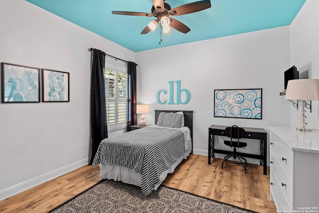 bedroom featuring light wood finished floors, a ceiling fan, and baseboards