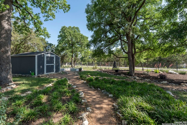 view of yard with fence, a storage unit, and an outbuilding
