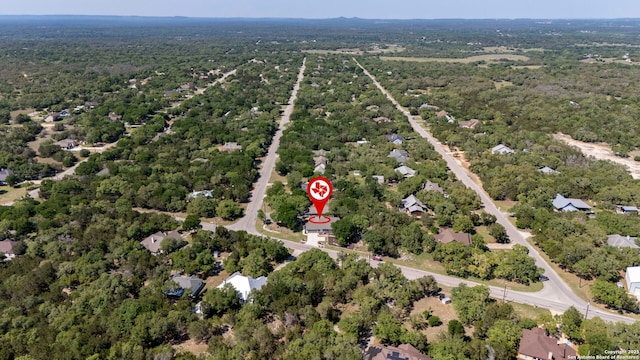 bird's eye view with a wooded view