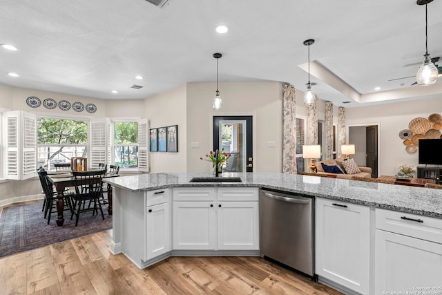 kitchen with plenty of natural light, dishwasher, open floor plan, and light wood-style floors