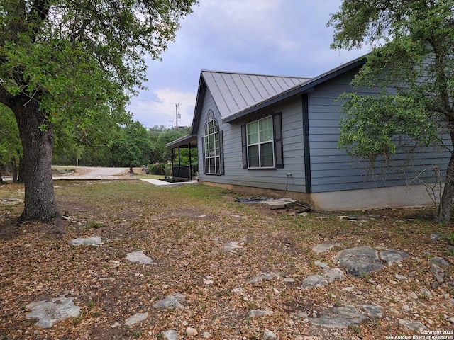 view of side of home featuring a standing seam roof and metal roof