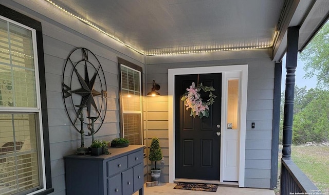 view of exterior entry featuring covered porch