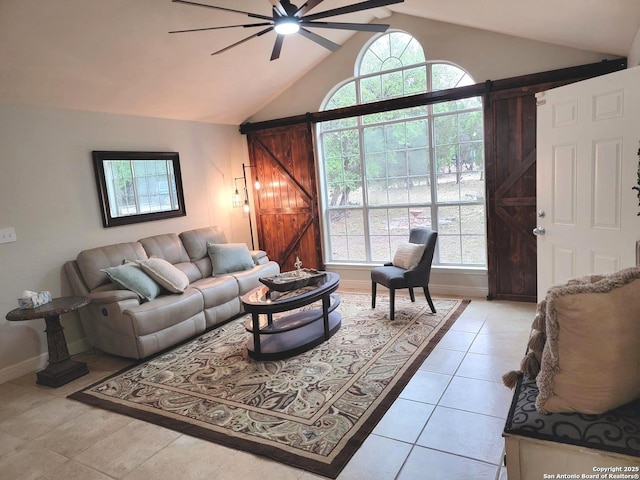 living area featuring ceiling fan, lofted ceiling, baseboards, and light tile patterned floors