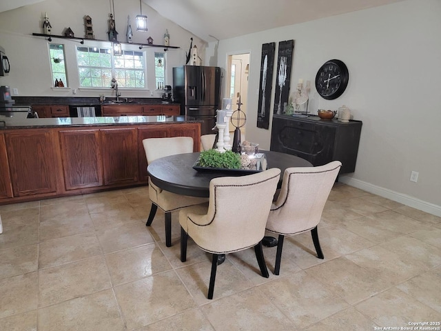 dining space with lofted ceiling and baseboards