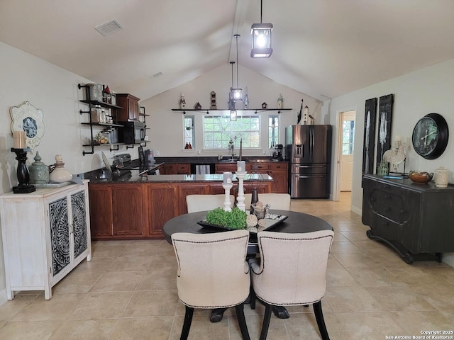 kitchen with open shelves, stainless steel fridge, dark countertops, and vaulted ceiling